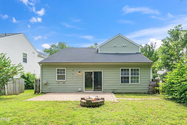 back of property with a patio area, roof with shingles, and an outdoor fire pit