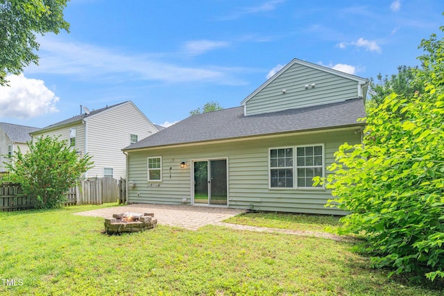 rear view of property featuring an outdoor fire pit, a patio area, and a shingled roof