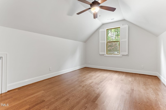 bonus room featuring ceiling fan, light wood-style floors, baseboards, and vaulted ceiling