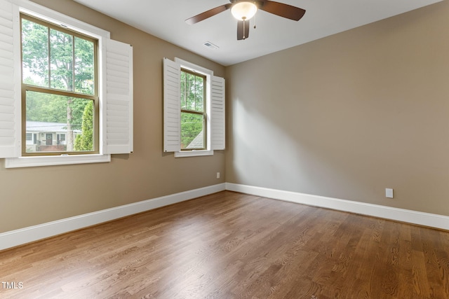 empty room featuring baseboards, ceiling fan, and wood finished floors