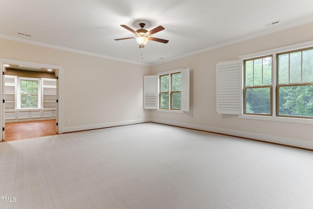 empty room with ceiling fan, crown molding, carpet floors, and baseboards