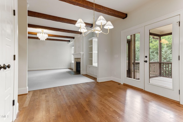 unfurnished living room with a chandelier, baseboards, wood finished floors, beam ceiling, and a fireplace with flush hearth