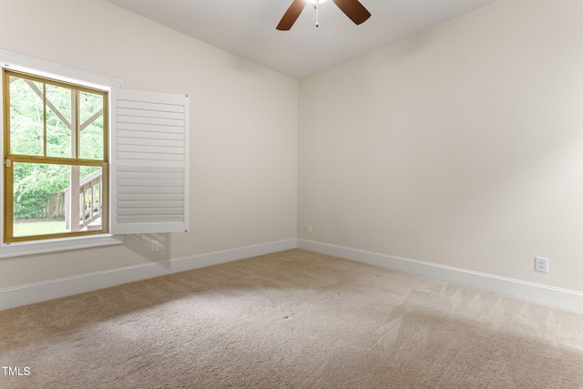 empty room featuring carpet floors, a ceiling fan, and baseboards
