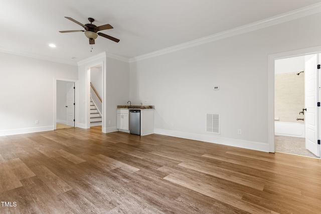 unfurnished living room with crown molding, stairs, ceiling fan, baseboards, and light wood finished floors