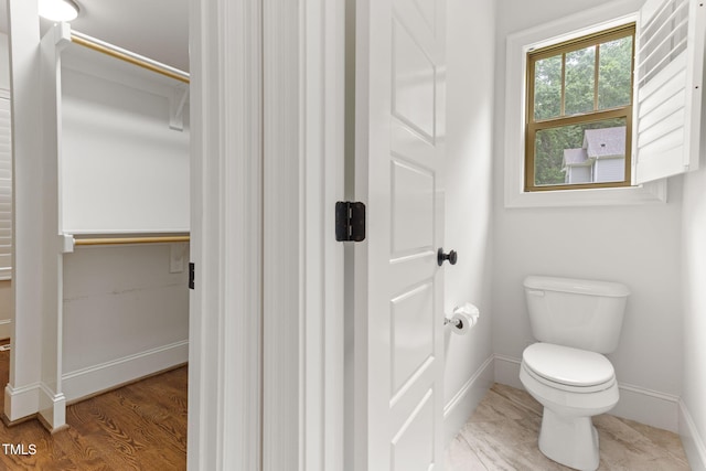 bathroom featuring baseboards, toilet, and wood finished floors