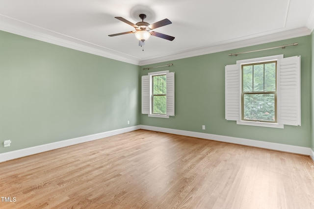 spare room with ornamental molding, wood finished floors, ceiling fan, and baseboards