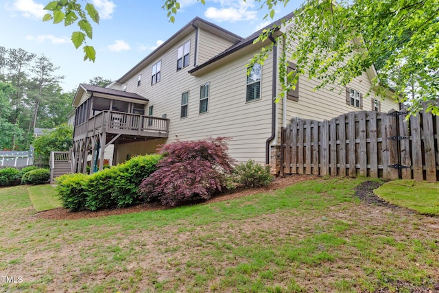 rear view of property with a sunroom, stairs, and a wooden deck