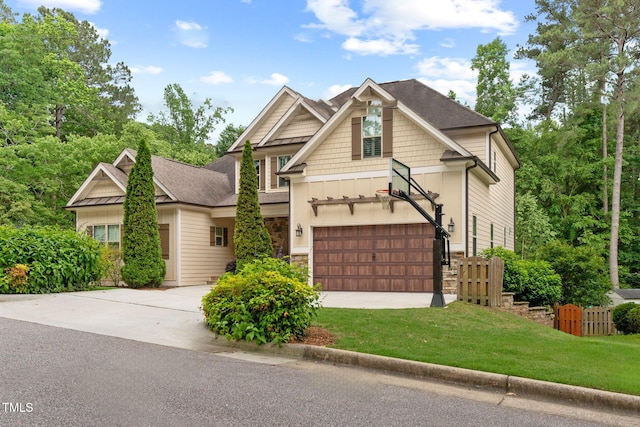 craftsman-style home with concrete driveway, board and batten siding, stone siding, a garage, and a shingled roof