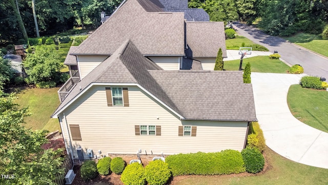 view of home's exterior featuring a shingled roof and a lawn