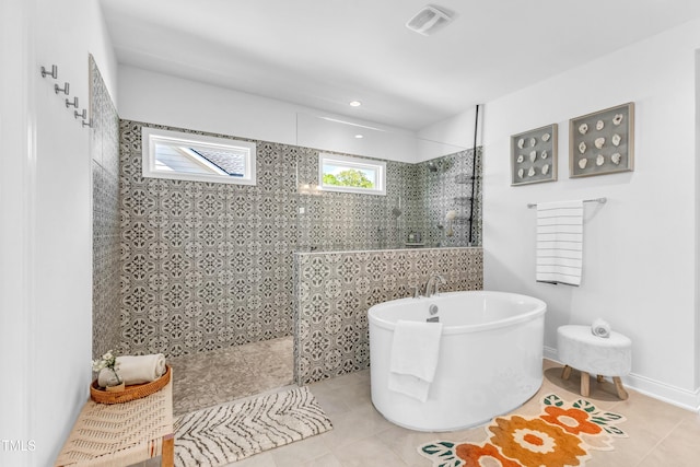 full bath featuring a walk in shower, tile patterned floors, and a freestanding tub
