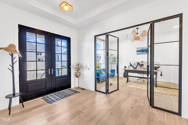 foyer entrance with french doors, light wood-style flooring, ornamental molding, and baseboards