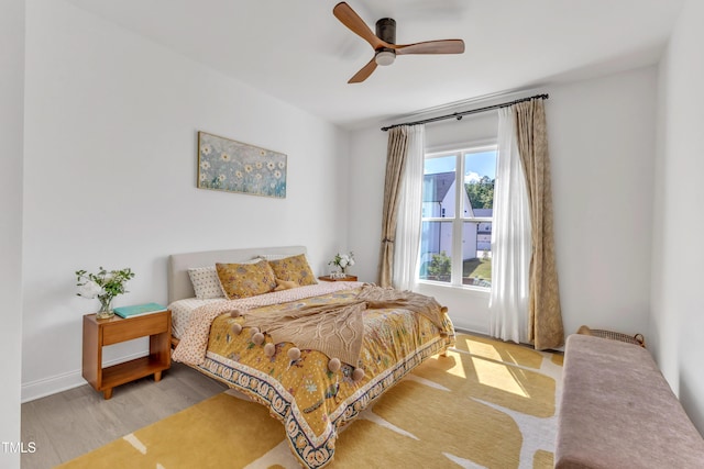 bedroom with wood finished floors, baseboards, and a ceiling fan
