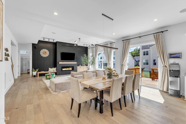 dining room with light wood-type flooring, recessed lighting, and a fireplace