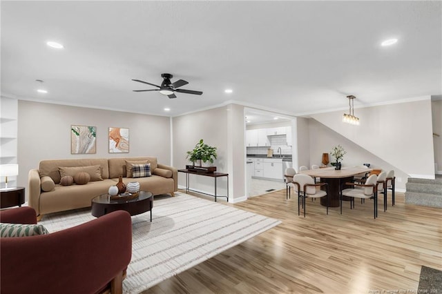 living room featuring ornamental molding, recessed lighting, light wood-style floors, a ceiling fan, and stairway