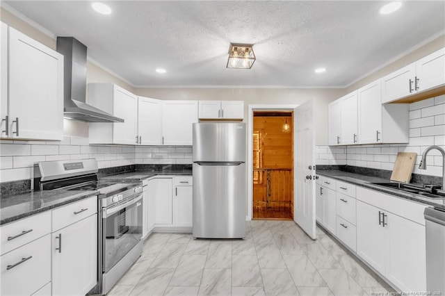 kitchen featuring appliances with stainless steel finishes, wall chimney exhaust hood, a sink, light marble finish flooring, and recessed lighting