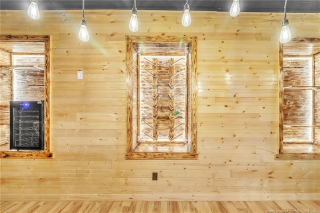 unfurnished room featuring wooden walls, wine cooler, and a relaxing sauna