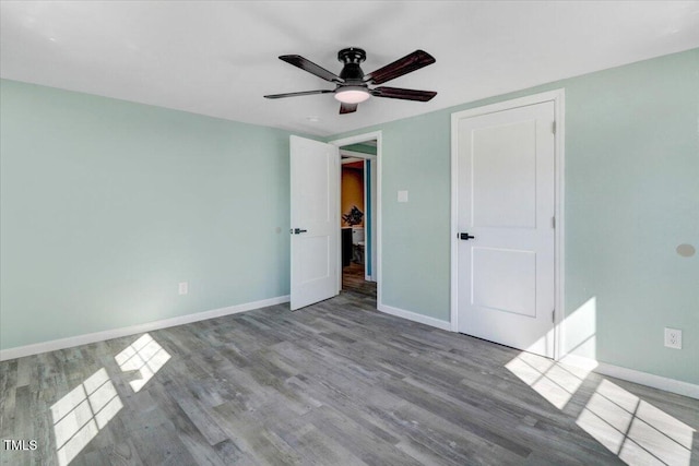 unfurnished bedroom featuring baseboards, wood finished floors, and ceiling fan