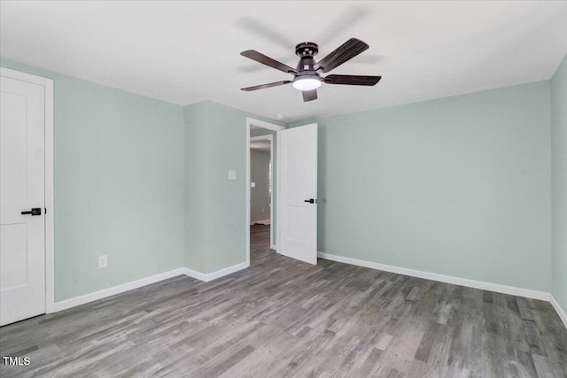unfurnished bedroom featuring baseboards, wood finished floors, and a ceiling fan