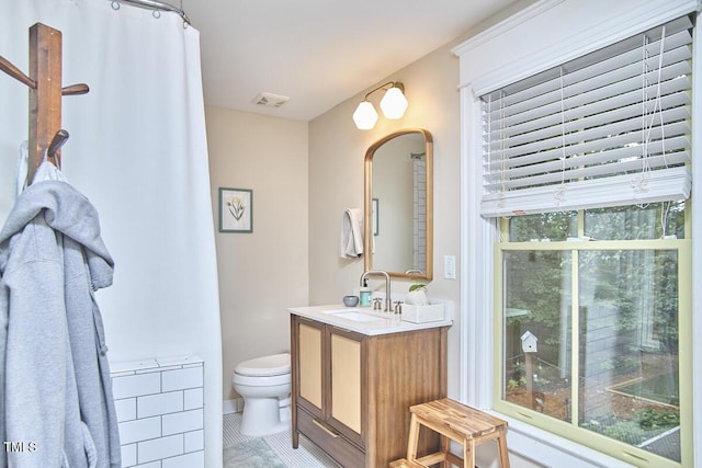full bath with toilet, vanity, and tile patterned floors