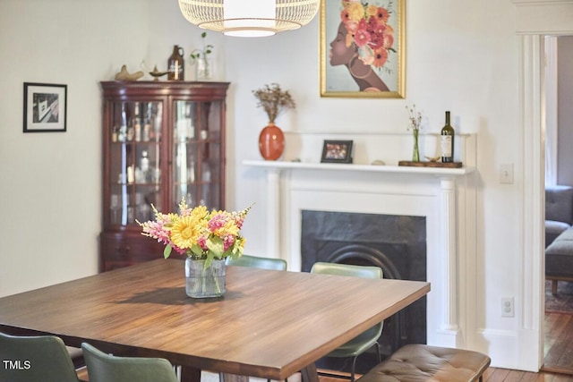 dining area with a fireplace and wood finished floors