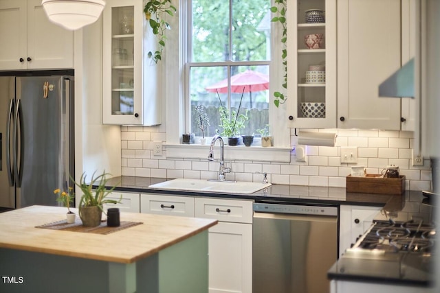 kitchen featuring appliances with stainless steel finishes, a sink, and white cabinetry