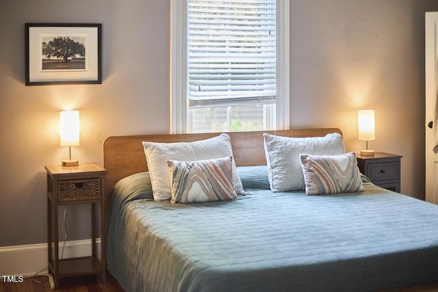 bedroom featuring wood finished floors and baseboards