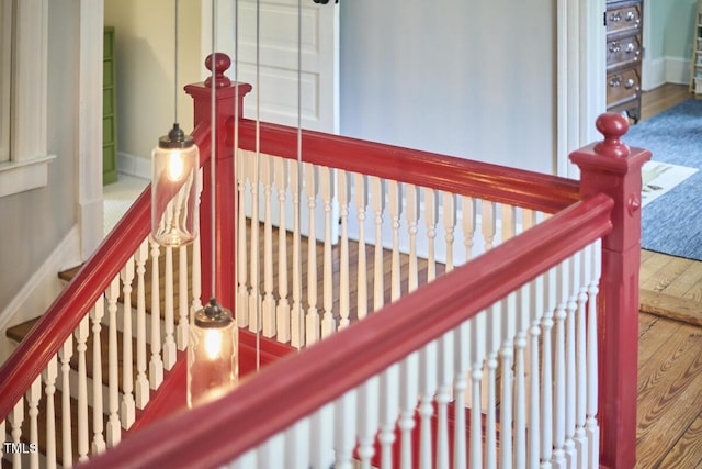 stairway featuring wood finished floors and baseboards