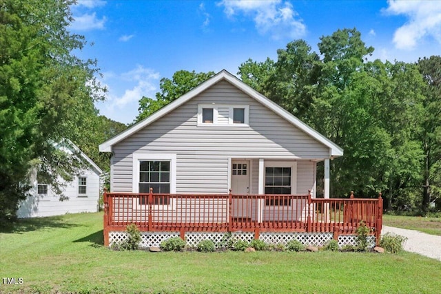 rear view of property featuring a lawn and a wooden deck