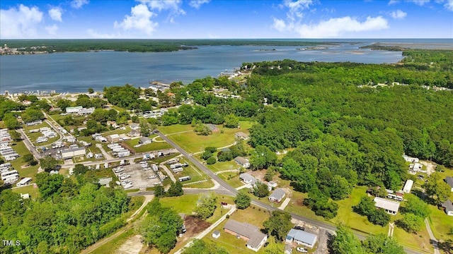 view of property location with a nearby body of water and a forest