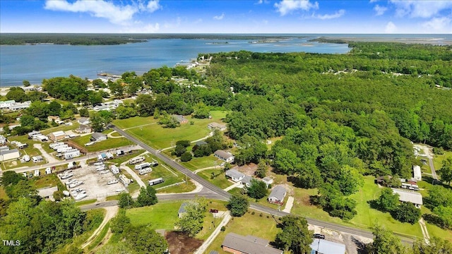 aerial view of property and surrounding area featuring a large body of water and a heavily wooded area