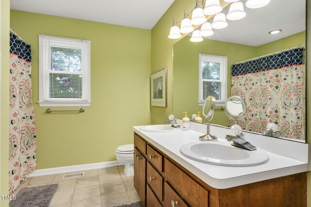 124 Windmere Dr, Angier, NC 27501 - full bathroom with baseboards, toilet, a chandelier, double vanity, and tile patterned flooring