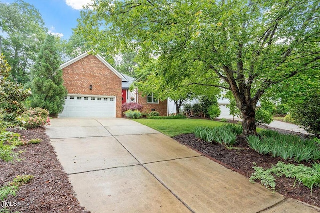 view of side of property with brick siding, driveway, a lawn, and a garage
