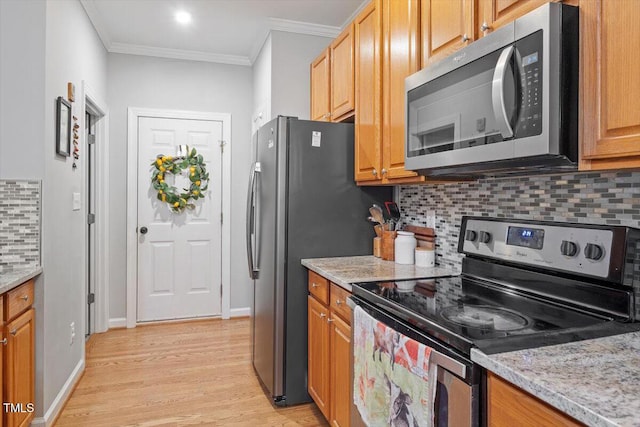 kitchen featuring stainless steel appliances, backsplash, crown molding, light wood-type flooring, and light stone countertops