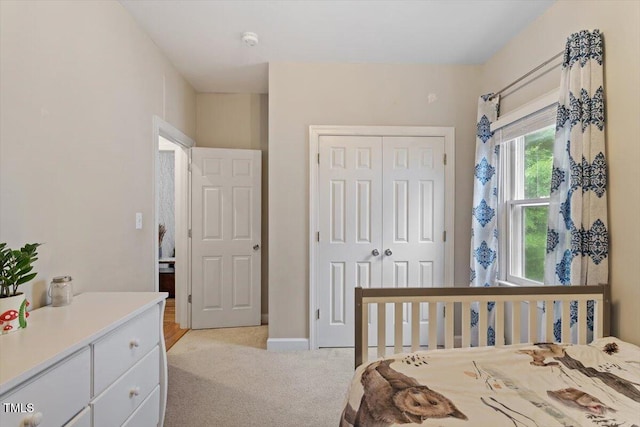 bedroom featuring light carpet and a closet