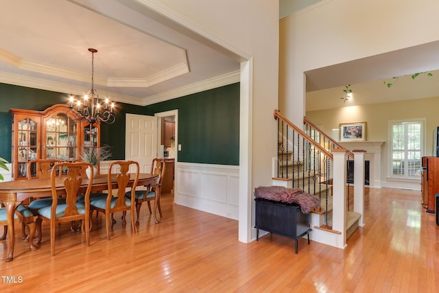 119 Marykirk Pl, Garner, NC 27529 - dining room featuring stairway, light wood-style floors, a chandelier, wainscoting, and crown molding