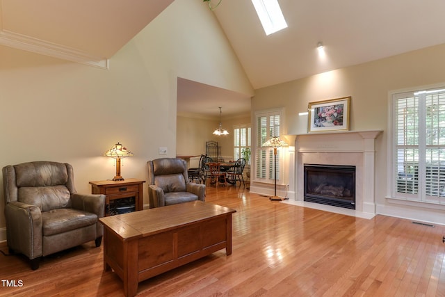119 Marykirk Pl, Garner, NC 27529 - living area with high vaulted ceiling, a chandelier, light wood finished floors, a fireplace, and healthy amount of natural light