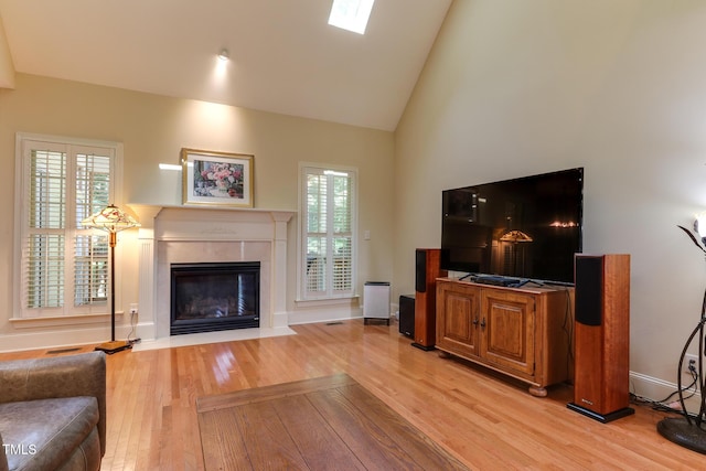 119 Marykirk Pl, Garner, NC 27529 - living room with light wood-style floors, a fireplace with flush hearth, high vaulted ceiling, healthy amount of natural light, and baseboards