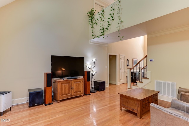 119 Marykirk Pl, Garner, NC 27529 - living room with stairway, light wood-type flooring, baseboards, a towering ceiling, and crown molding