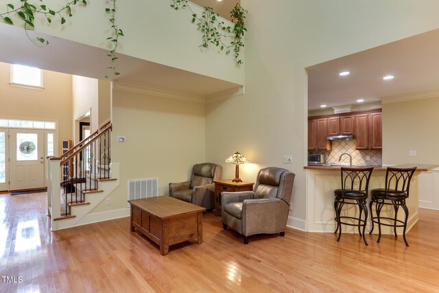 119 Marykirk Pl, Garner, NC 27529 - living room with a high ceiling, light wood-type flooring, crown molding, stairs, and recessed lighting
