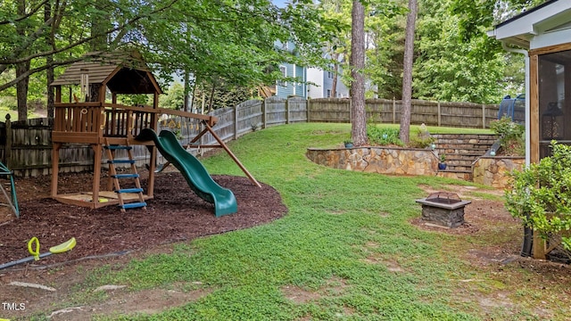 view of yard with an outdoor fire pit and a playground