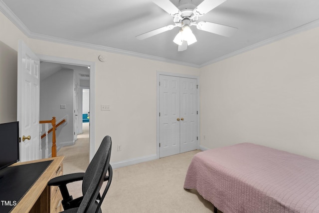 bedroom featuring light carpet, crown molding, baseboards, ceiling fan, and a closet