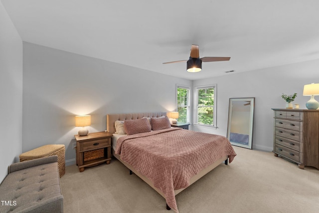 bedroom with light colored carpet, ceiling fan, and baseboards