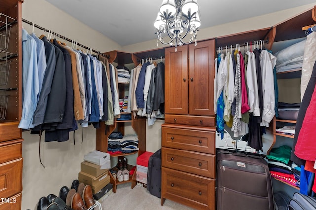 walk in closet with light colored carpet and a chandelier