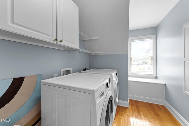 laundry room with washing machine and dryer, cabinet space, light wood-type flooring, and baseboards