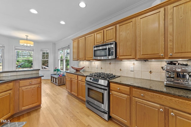 kitchen featuring stainless steel appliances, decorative backsplash, light wood-style flooring, recessed lighting, and dark stone counters