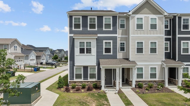 6352 Perry Creek Rd, Raleigh, NC 27616 - view of property with a residential view, stone siding, roof with shingles, and a front lawn