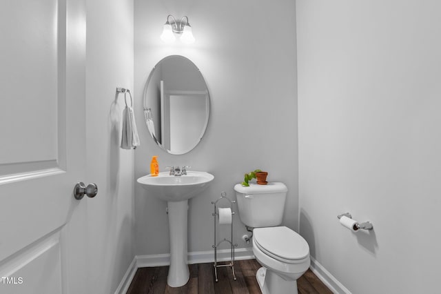 6352 Perry Creek Rd, Raleigh, NC 27616 - half bathroom with wood finished floors, toilet, baseboards, and a sink