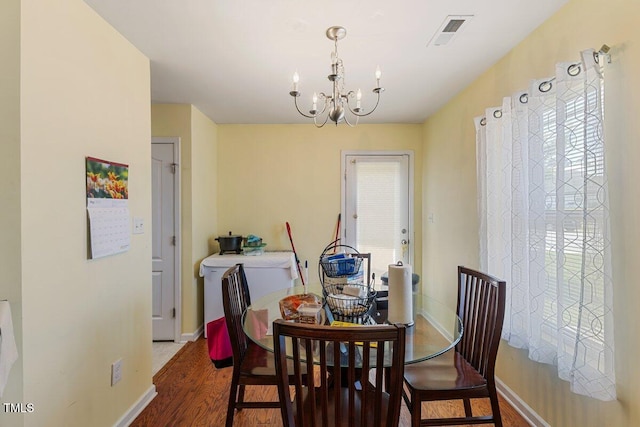 dining room with wood finished floors, a chandelier, and baseboards