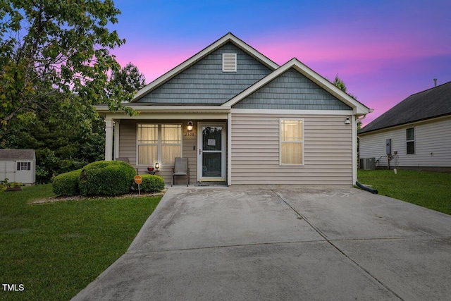 view of front of property featuring a yard and central air condition unit