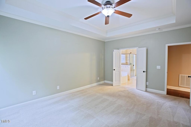 337 Shadowdale Ln, Rolesville, NC 27571 - unfurnished bedroom featuring a tray ceiling, ornamental molding, light colored carpet, baseboards, and ensuite bathroom